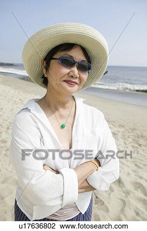 Stock Image - Middle-aged woman on beach. Fotosearch