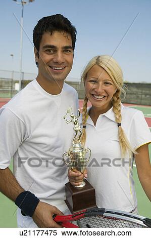 Mixed doubles Tennis Players on tennis court holding trophy, portrait View Large Photo Image Stock Photography - Mixed doubles Tennis Players on tennis court holding trophy, portrait. Fotosearch