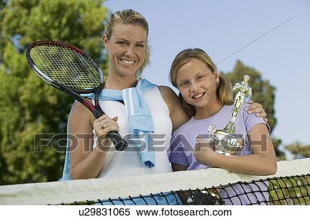 Mother and Daughter at Tennis Net with Trophy, portrait, low angle view View Large Photo Image Stock Photography - Mother and Daughter at Tennis Net with Trophy, portrait, low angle view. Fotosearch