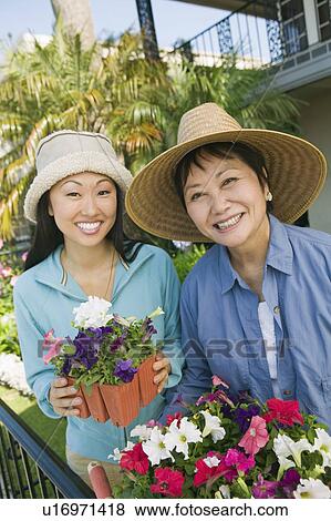 Mother and daughter in garden, smiling, (portrait) View Large Photo Image Stock Photo - Mother and daughter in garden, smiling, (portrait). Fotosearch