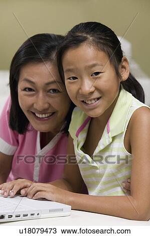 Mother and Daughter in living room Using Laptop Together, portrait View Large Photo Image Stock Image - Mother and Daughter in living room Using Laptop Together, portrait. Fotosearch
