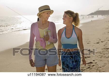 Stock Photo - Mother and Daughter Walking on Beach. Fotosearch