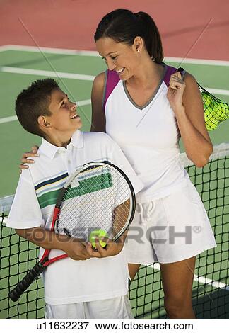Mother and son by net on tennis court, high angle view View Large Photo Image Stock Photo - Mother and son by net on tennis court, high angle view. Fotosearch