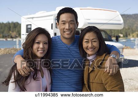 Stock Photography - Parents and teenage daughter outside of RV. Fotosearch