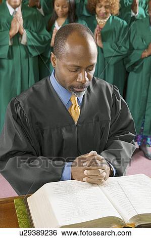 Stock Photograph - Preacher by altar in church Bowing Head in Prayer, high angle view. Fotosearch