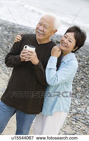 Senior couple at beach looking at camera View Large Photo Image Stock Photo - Senior couple at beach looking at camera. Fotosearch