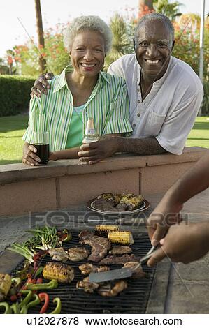 Stock Photo - Senior Couple at outdoor barbecue, portrait.. Fotosearch