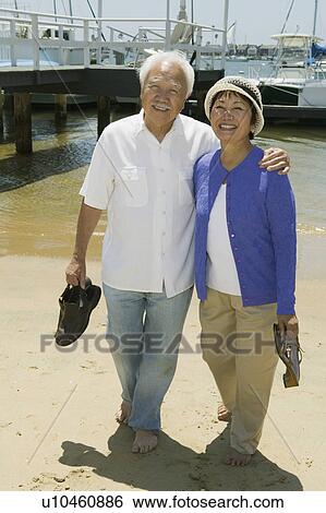 Stock Photograph - Senior couple on beach, (portrait). Fotosearch