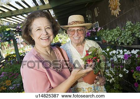 Senior Couple Shopping for flowers at plant nursery, portrait View Large Photo Image Stock Photo - Senior Couple Shopping for flowers at plant nursery, portrait. Fotosearch