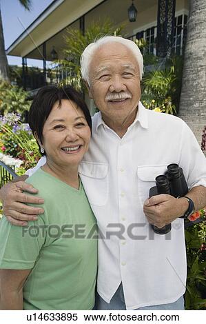 Stock Photography - Senior couple with binoculars, outdoors, (portrait). Fotosearch