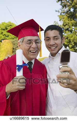 Senior Graduate and son taking picture with cell phone outside View Large Photo Image Stock Photography - Senior Graduate and son taking picture with cell phone outside. Fotosearch