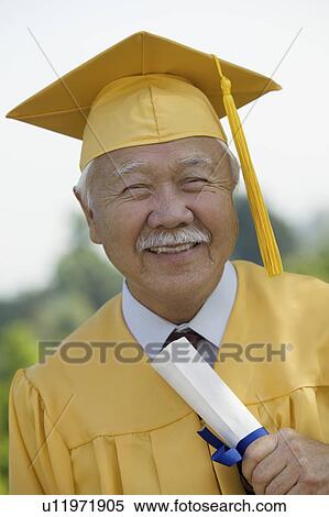 Stock Photography - Senior Graduate holding diploma outside, portrait. Fotosearch