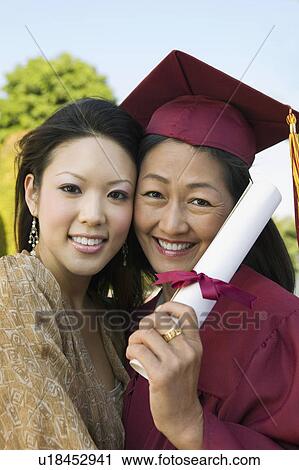 Stock Image - Senior Graduate hugging daughter outside, portrait. Fotosearch