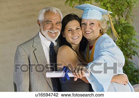 Senior graduate hugging granddaughter with husband outside View Large Photo Image Stock Image - Senior graduate hugging granddaughter with husband outside. Fotosearch