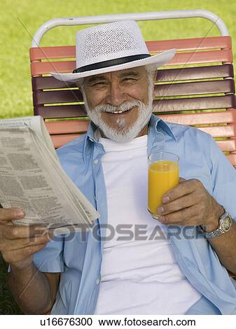 Senior Man sitting on Lawn Chair holding Newspaper and Orange Juice, elevated view portrait. View Large Photo Image Stock Image - Senior Man sitting on Lawn Chair holding Newspaper and Orange Juice, elevated view portrait.. Fotosearch