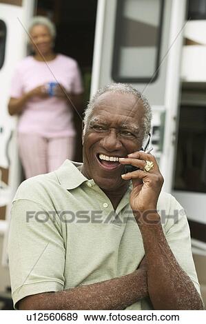 Stock Photo - Senior man using mobile phone, outdoors. Fotosearch