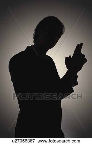 Stock Photo - Shadow of man making gun-shaped gesture, side view. Fotosearch