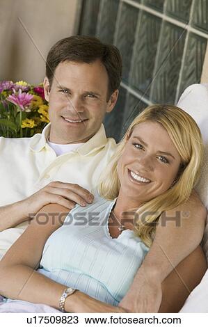 Stock Image - Smiling Couple Sitting Together. Fotosearch