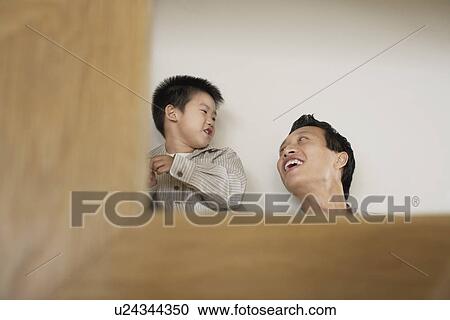 Smiling father and son playing View Large Photo Image Stock Image - Smiling father and son playing. Fotosearch
