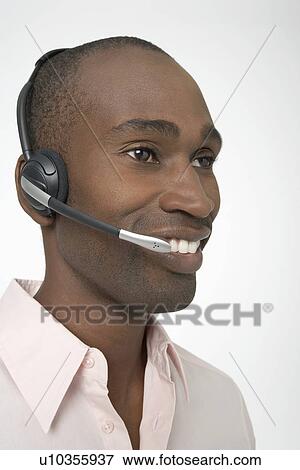 Stock Photo - Smiling man talking on Telephone Headset. Fotosearch