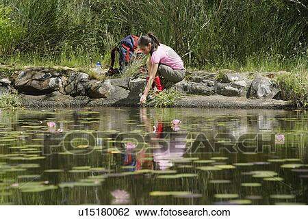Teenage girl (16-17 years) squatting by lake View Large Photo Image Stock Image - Teenage girl (16-17 years) squatting by lake. Fotosearch