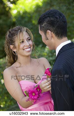 Teenage girl pinning boutonnière on date outside View Large Photo Image Stock Image - Teenage girl pinning boutonnière on date outside. Fotosearch