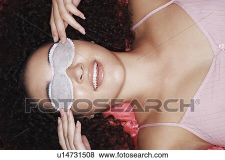 Stock Photo - Teenage Girl Wearing Sleep Mask, overhead view, close-up. Fotosearch