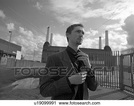 Stock Image - Teenager (16-18) adjusting tie, portrait. Fotosearch