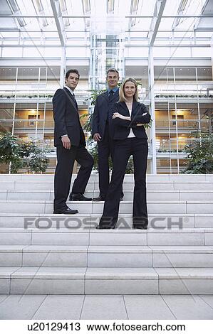 Three businesspeople standing outside office, portrait View Large Photo Image Stock Image - Three businesspeople standing outside office, portrait. Fotosearch