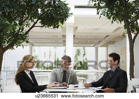 Stock Image - Three businesspeople working outdoors. Fotosearch