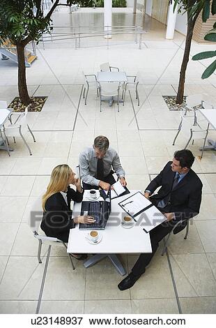 Stock Photo - Three businesspeople working outdoors, elevated view. Fotosearch