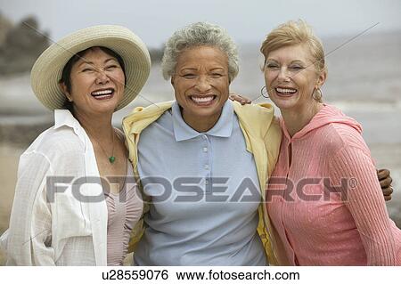 Three female friends embracing at beach, (portrait) View Large Photo Image Stock Photograph - Three female friends embracing at beach, (portrait). Fotosearch