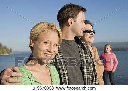 Three-generation family standing on lake shore View Large Photo Image Stock Photo - Three-generation family standing on lake shore. Fotosearch