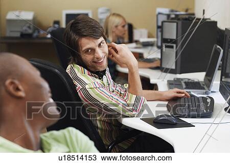 Three people sitting at desk using computers, two men talking. View Large Photo Image Stock Image - Three people sitting at desk using computers, two men talking.. Fotosearch