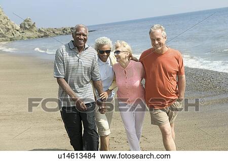 Picture - Two couples walking on beach. Fotosearch