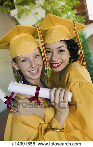 Two graduates hugging outside, portrait View Large Photo Image Stock Photo - Two graduates hugging outside, portrait. Fotosearch