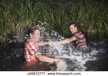Two teenage boys (16-17 years) messing about in water, splashing View Large Photo Image Stock Photo - Two teenage boys (16-17 years) messing about in water, splashing. Fotosearch