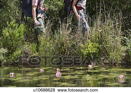 Two teenage boys (16-17 years) walking by lake carrying backpacks, low section View Large Photo Image Stock Photo - Two teenage boys (16-17 years) walking by lake carrying backpacks, low section. Fotosearch