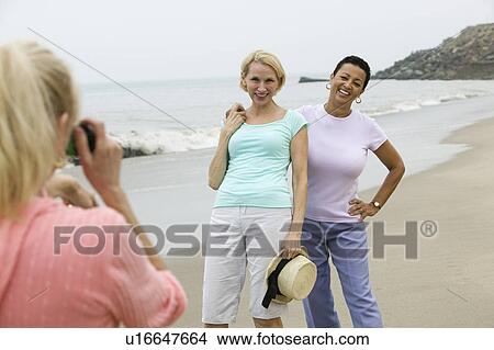 Two women being photographed on beach View Large Photo Image Picture - Two women being photographed on beach. Fotosearch