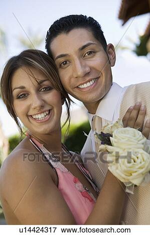 Stock Photo - Well-dressed teenage couple outside school dance, portrait. Fotosearch