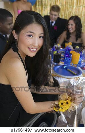 Stock Photo - Well-dressed teenager girl sitting at school dance. Fotosearch