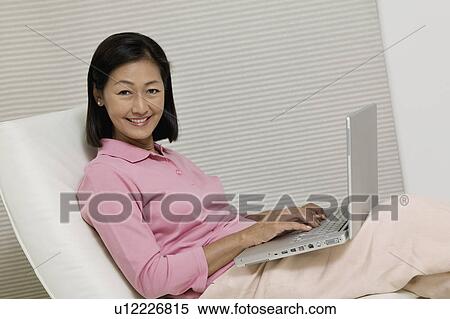 Woman in Chair Using Laptop, portrait View Large Photo Image Stock Photography - Woman in Chair Using Laptop, portrait. Fotosearch