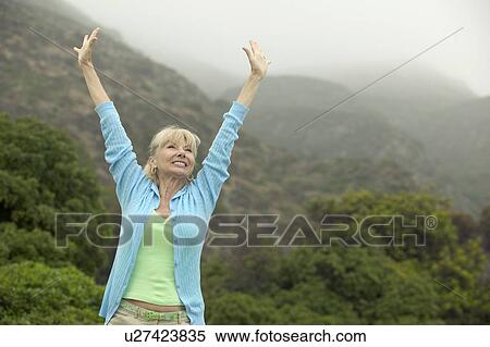 Woman raising arms near forest View Large Photo Image Stock Photography - Woman raising arms near forest. Fotosearch