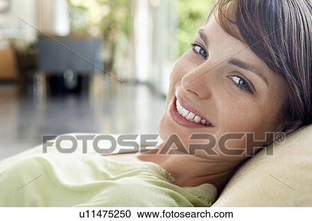 Woman relaxing on sofa, close-up, portrait View Large Photo Image Stock Image - Woman relaxing on sofa, close-up, portrait. Fotosearch