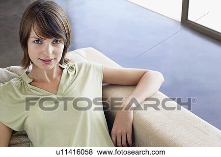 Woman relaxing on sofa, elevated view, portrait View Large Photo Image Stock Photo - Woman relaxing on sofa, elevated view, portrait. Fotosearch