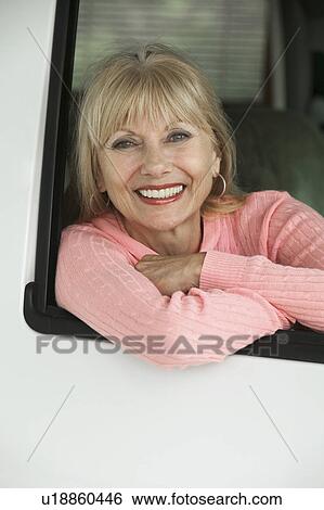 Stock Photograph - Woman smiling in vehicle, (portrait). Fotosearch