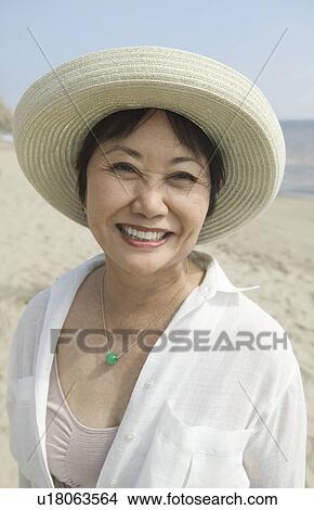 Woman smiling on beach, (close-up), (portrait) View Large Photo Image Picture - Woman smiling on beach, (close-up), (portrait). Fotosearch