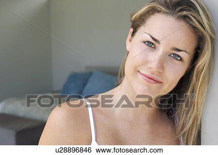 Stock Photograph - Woman standing at bedroom door, portrait. Fotosearch