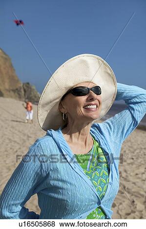 Woman wearing summer hat on beach View Large Photo Image Stock Photo - Woman wearing summer hat on beach. Fotosearch