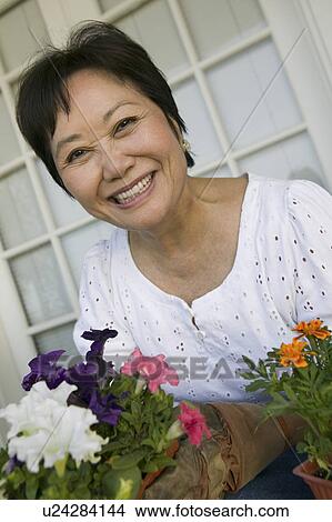 Picture - Woman with flowers, outdoors, (portrait). Fotosearch